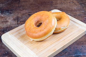 Ciambella in primo piano su tagliere, ciambella semplice, ciambella con zucchero