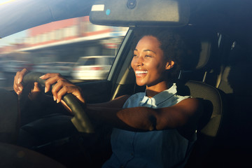 Young african american woman driving a car - Powered by Adobe