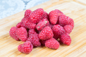 Lamponi in primo piano, frutta fresca, lamponi rossi su tagliere in primo piano