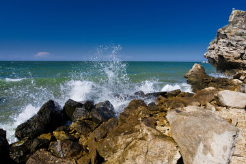 the waves splashing on the beach with rocks