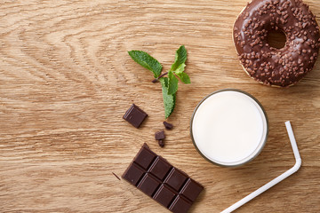 Three chocolate donuts on wooden rustic table