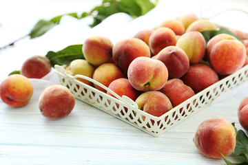 Sweet peach fruit in tray on white wooden table