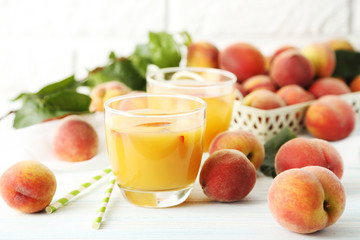 Fototapeta na wymiar Glasses of peach juice on white wooden table
