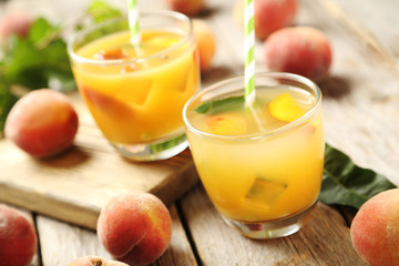 Glasses of peach juice on grey wooden table