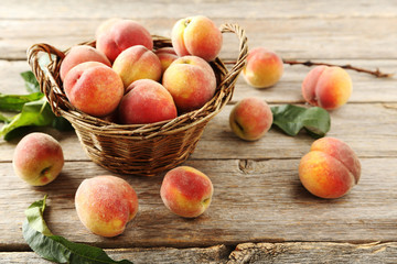 Sweet peach fruit in basket on grey wooden table