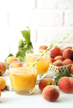 Glasses of peach juice on white wooden table