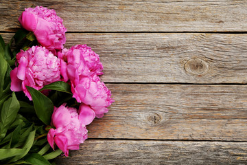 Bouquet of pink peony flowers on wooden table