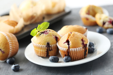 Muffins with blueberries on a grey table