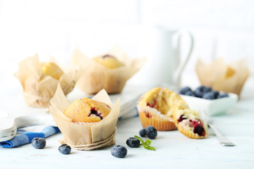 Muffins with blueberries on blue wooden table