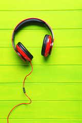 Headphones on a green wooden table, close up