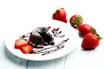 Chocolate fondant with strawberry on blue wooden table