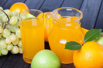different fruits and juice in the jug still life