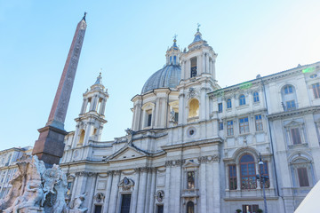 Fototapeta na wymiar Ancient Egyptian Monument and Church of Sant'Agnese de Agony in the baroque Piazza Navona in Rome. Italy. Part of the facade of the cathedral and a monument on the Piazza Navona.