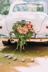 Vintage wedding car with just married sign and cans attached, close-up