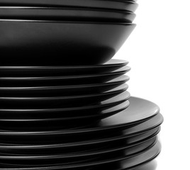 Stack of different black ceramic plates, isolated on white