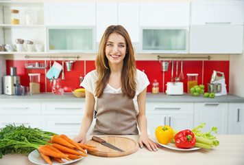 Beautiful girl cutting vegetables in kitchen