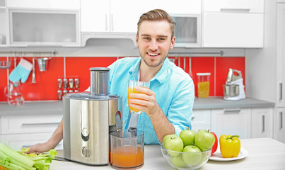 Fototapeta premium Handsome man with juice in kitchen