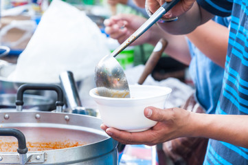 hand  holding Spoon food in the foam tray ,streetfood