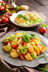 Fried potato salad with lettuce, pepper, onion and baked fish fillets covered with cheese