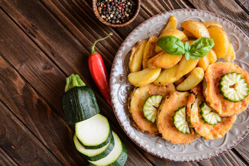 Breaded fried zucchini with American potatoes and cucumber