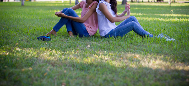  Two teen girl friends siting on grass