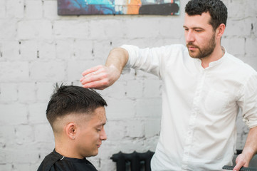 Male Barber Giving Client Haircut In Shop