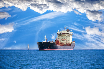 Oil tanker ship at sea on a background of blue sky.