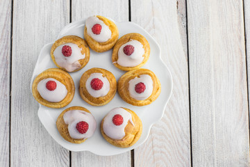 Top View on Raspberries Profiterole with White Chocolate on Plat