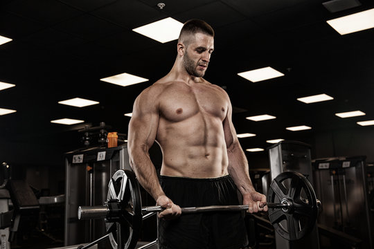 very power athletic guy bodybuilder , execute exercise with dumbbells