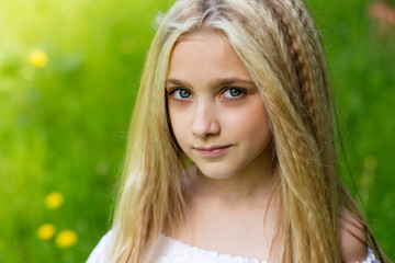 Portrait cute blonde girl outdoors in summer