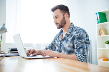 Side view of concentrated man writing book on laptop