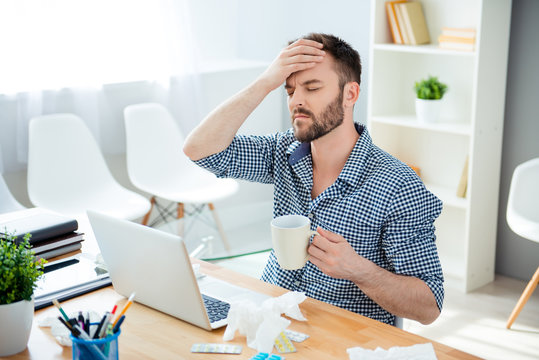 Sick businessman with temperature and headache working in office