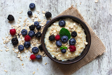 Obraz na płótnie Canvas oatmeal porridge with ripe berries for breakfast. top view