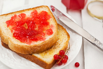 Fresh toasts with jelly, cup of coffee and fruits for breakfast