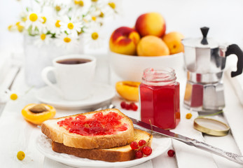 Fresh toasts with jelly, cup of coffee and fruits for breakfast