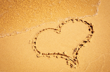 Heart drawing in the sand beach. 