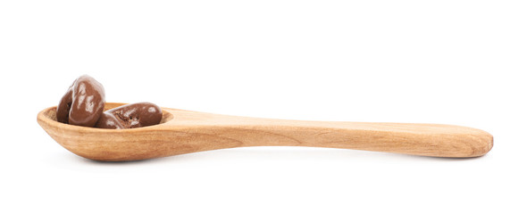 Spoon of chocolate candies isolated
