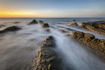 Beautiful sunset decorated with waves and mosses stone