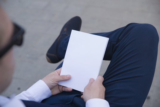 Mockup Cover Magazine, Catalog, Book.
Man Reading A Blank Magazine, Catalog, Book On The Bench.