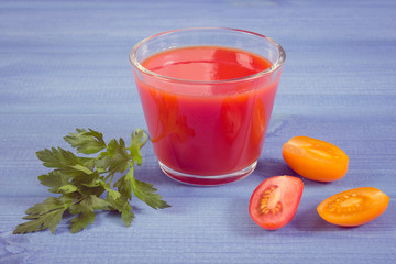 Vintage photo, Tomato juice and vegetables on blue board, healthy nutrition