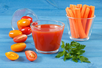Tomato juice and vegetables on blue board, healthy nutrition