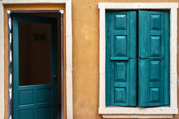 Obraz na płótnie Canvas Green wooden window and door on yellow wall