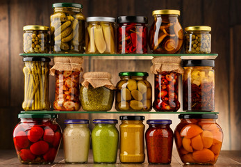 Jars with variety of pickled vegetables.