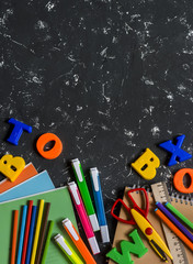 School accessories on a dark background. Top view, free space for text
