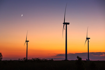 Obraz premium Wind turbine power generator silhouette at sunset