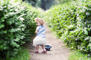 Little cute cheerful girl walking in summer park, outdoor