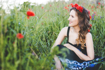 Beautiful young woman on the poppy field