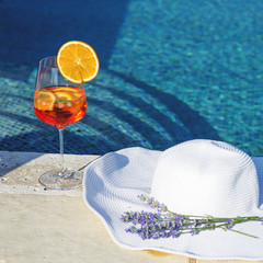 Cocktail and white hat near swimming pool