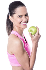 Female instructor about to eat fresh green apple