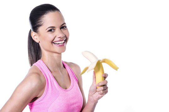 Fitness woman eating fresh ripe banana